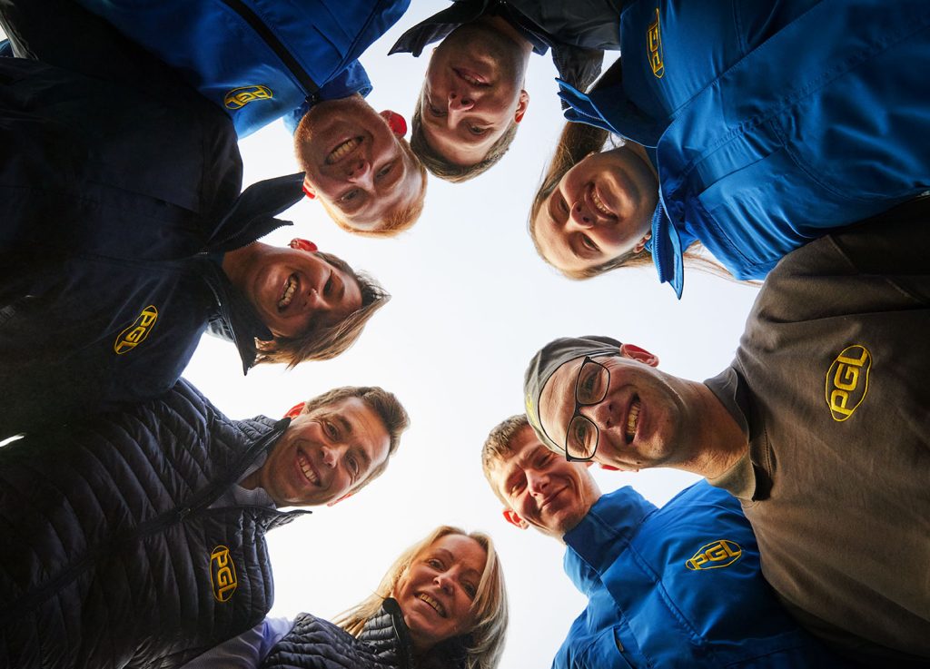 Group of PGL colleagues smiling in a circle