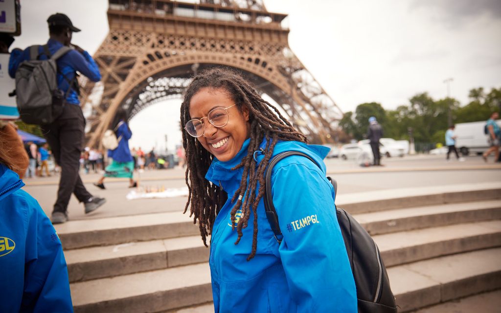 PGL Tour Leader stood smiling in front of the Eiffel Tower