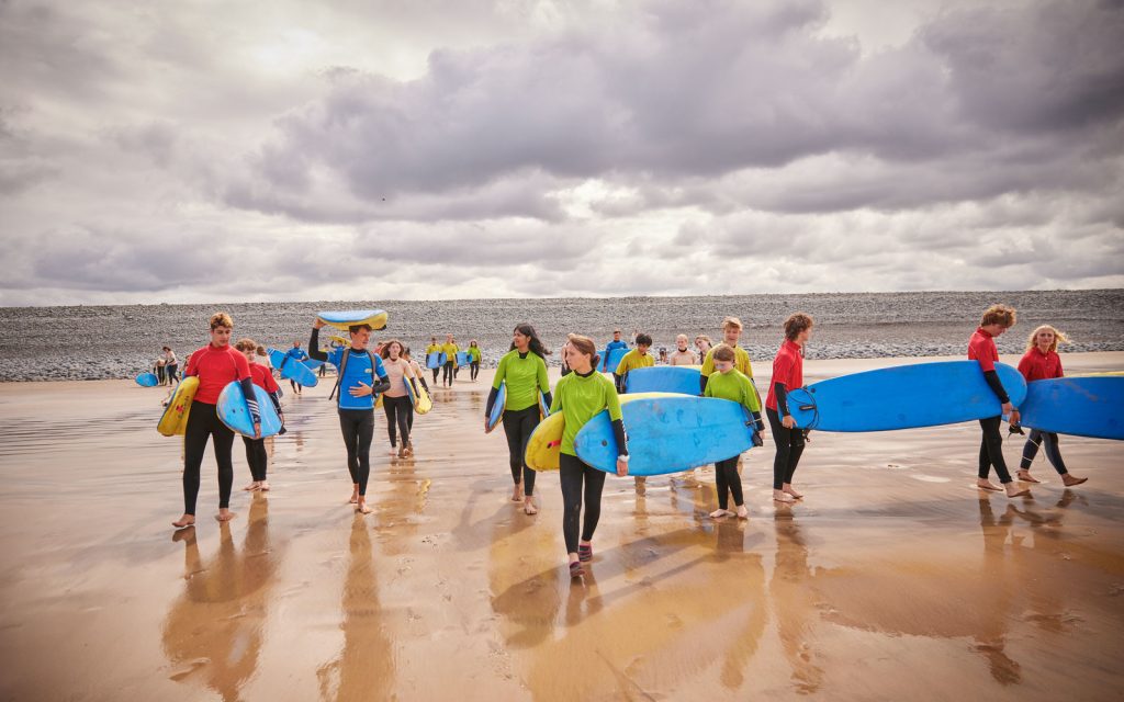 PGL instructors teaching children and young adults to surf in Devon