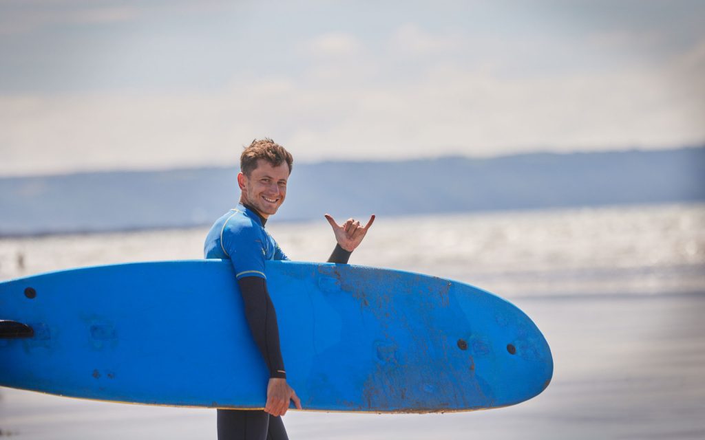 A PGL surfing instructor working on the beach in Devon