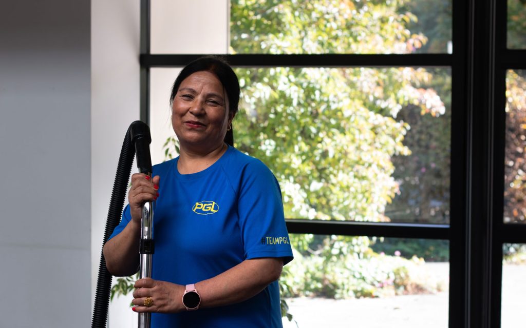 Smiling Housekeeping Assistant in PGL uniform