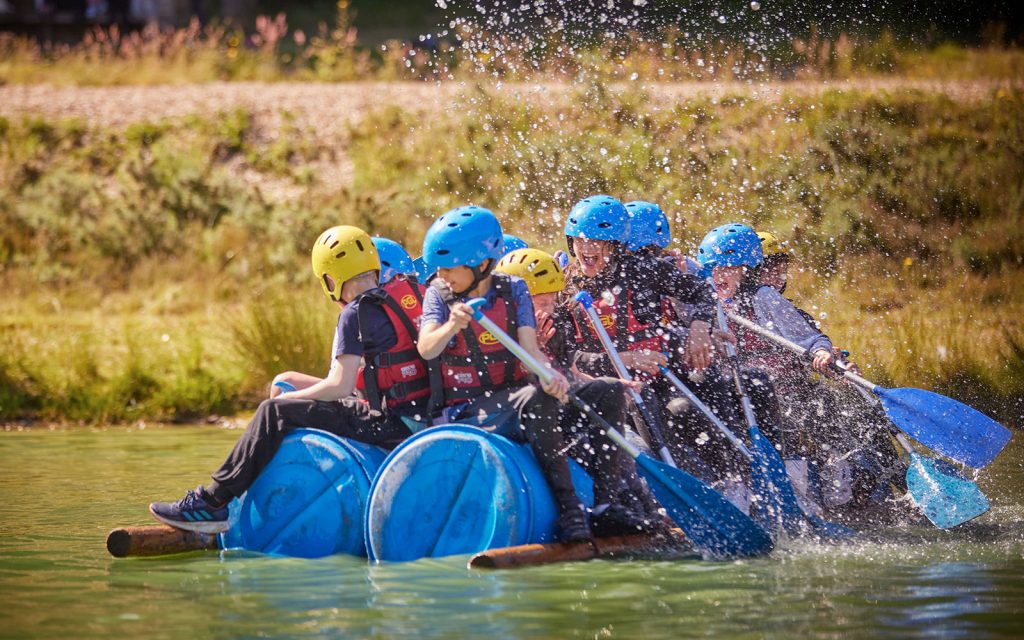 Children on a raft on a lake, splashing water