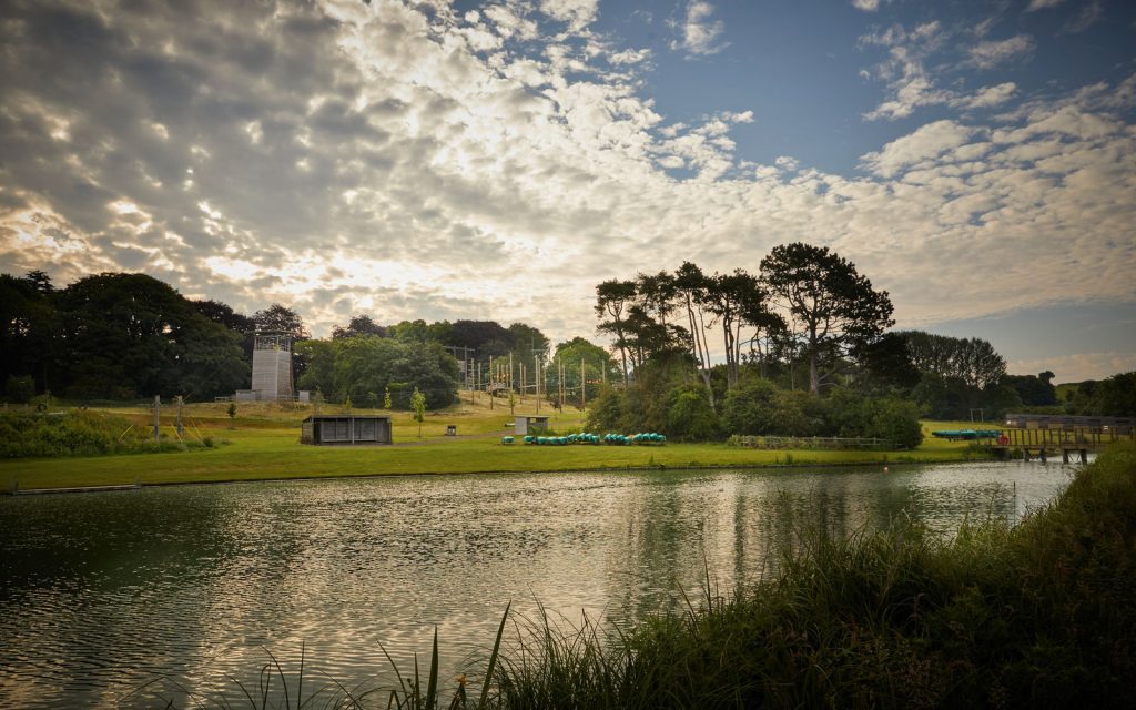 The lake at Caythorpe Court with abseil tower, canoes and high ropes in the background.